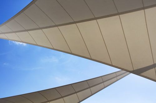 Bottom view of triangle shaped big sun shades and clear blue sky